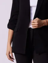Blazer rojo de crepe marca Tahari, con cuello con solapa y abertura central. Largo de manga ¾ regulable con presilla y botón. Delantera con bolsillos y forro interno.