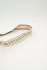 Bolso tipo bombonera tejido a crochet, con patrón geométrico en tonos rosa y marrón. Tiene cierre con cordón ajustable y correa de hombro.