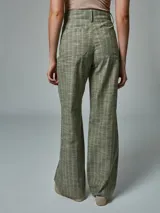 Pantalón de lino color ladrillo con estampado a cuadros blancos, de corte palazzo y tiro alto.