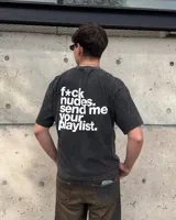 Remera negra con efecto gastado y estampado en la espalda con la frase 'f*ck nudes. send me your playlist.' en letras blancas.