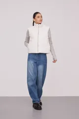 Chaleco blanco con cuello alto y cierre frontal con cremallera.