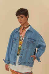 Chaqueta vaquera azul de corte oversize, con cuello clásico, cierre de botones, bolsillos frontales y puños abotonados.