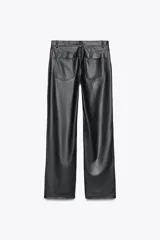 Pantalón negro de tiro medio, con trabillas en la cintura, cinco bolsillos y pernera ancha. Cierre frontal con cremallera, botón oculto y gancho metálico.