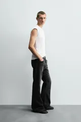 Pantalón de jean celeste, de tiro medio, corte ajustado en la parte superior y acampanado desde la rodilla. Tiene cinco bolsillos, efecto lavado y bajo irregular.