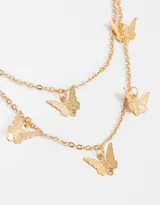 Collar corto dorado de doble cadena con dijes de mariposas.