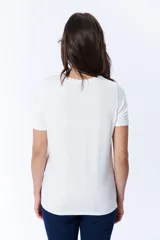 Remera manga corta color crudo con cuello redondo a la base.