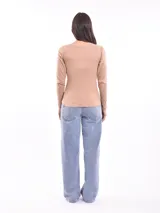 Remera de manga larga color fucsia con cuello redondo y detalle de pequeñas tachas plateadas alrededor del cuello.