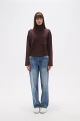 Buzo negro de manga larga con cuello alto tipo chimenea y un bolsillo cuadrado en el pecho.