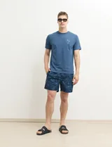 Short de baño azul con estampado abstracto en blanco.