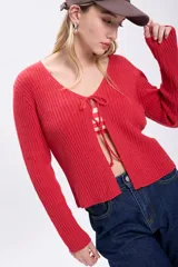 Cardigan rojo de tejido rib con escote en V y ajuste frontal con lazos.