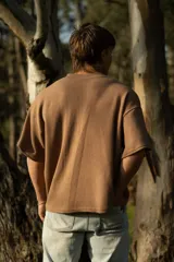 Remera marrón de manga corta confeccionada en punto Prato, con bordado frontal con la palabra 'bouuwana'. De calce relajado y textura suave.
