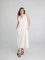 Vestido midi sin mangas color crema, con cuello polo y escote en V.