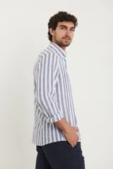 Camisa de lino a rayas verticales azules y blancas, de manga larga con puños abotonados y cuello clásico.