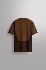 Camiseta deportiva marrón confeccionada en tejido técnico ligero y elástico con estructura perforada. Cuello redondo, manga corta y bajo asimétrico con aberturas laterales. Detalle de logo estampado.