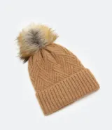Gorro de lana color camel con textura en punto trenzado y pompón de pelo sintético en la parte superior.
