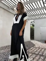 Vestido largo negro con paneles blancos en escote, mangas y ruedo.