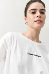 Remera color beige de manga corta con bordado frontal con la frase “L’amour toujours”.