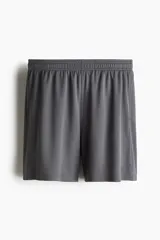 Short deportivo gris de tejido funcional de secado rápido con cintura elástica con cordón ajustable, bolsillos laterales y aberturas laterales en el bajo.
