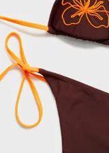 Braga de bikini color marrón con tiras laterales ajustables color naranja.