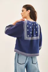 Saco azul marino de algodón con bordados blancos en el frente y mangas 3/4 abullonadas.
