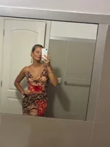 Vestido largo de microtul con estampado animal print y flores rojas. Tiene espalda descubierta con tiras finas cruzadas.