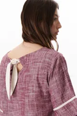 Blusa azul de lino con escote barco y mangas 3/4 con detalle de ribete blanco.