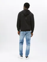 Buzo negro con cierre de cremallera y capucha ajustable, de corte relaxed y logo de Tommy Jeans bordado en el pecho y en el puño.