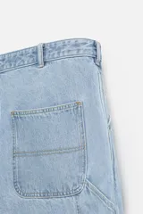 Pantalón de jean negro, corte relaxed fit, con bolsillos frontales y traseros tipo parche, tira multifunción y bolsillo tipo parche en las piernas. Tiene efecto lavado y cierre frontal con cremallera y botón.