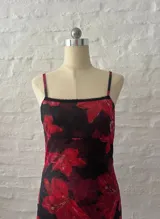 Minivestido de microtul con estampado de flores rojas sobre fondo negro.