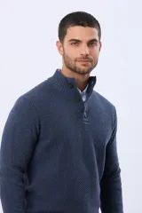 Buzo tejido de punto color azul marino, con cuello alto y medio botón frontal. Presenta un patrón texturizado y puños y dobladillo acanalados.