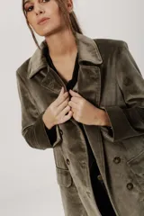 Chaqueta de terciopelo color verde oliva, con cuello solapa, doble botonadura y corte holgado.