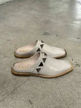 Sueco de cuero negro con detalle de apliques metálicos triangulares plateados.