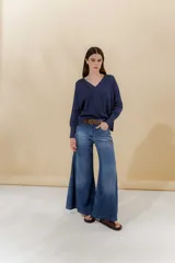 Pantalón de jean azul de corte amplio con paneles y ruedo acampanado.