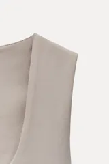 Camiseta blanca de tirantes anchos, corte ajustado, escote redondo y largo a la cadera.