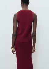 Chaleco de tejido de punto fino color rojo oscuro (vino), con cuello de pico, tirantes anchos y cierre frontal con botones.