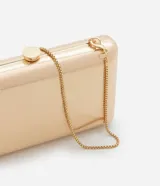 Cartera clutch rectangular rígida color dorado, con textura acanalada y cierre de broche. Incluye correa de cadena dorada desmontable.