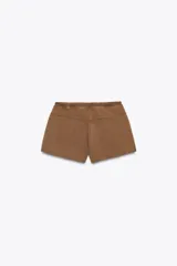 Shorts color marrón de algodón con efecto lavado, tiro medio, cintura elástica ajustable con cordones y detalle de tachas plateadas.