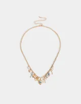 Collar corto dorado con cadena de eslabones y dijes colgantes de corazón, llave, mariposa y camafeo con flores.