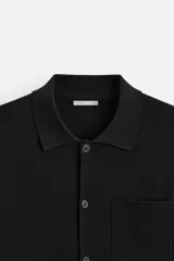 Cárdigan negro de punto de algodón, corte regular, con cuello solapa, manga larga, bolsillo de parche en el pecho y cierre frontal con botones.