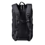 Mochila negra de 25 litros, fabricada con ripstop resistente al agua y panel frontal impermeable. Cuenta con sistema de cierre Slide-Lock para acoplar módulos, apertura principal en forma de U, bolsillo superior externo, compartimento acolchado para laptop, correas de hombro contorneadas y acolchadas, correa de esternón ajustable, correa de cintura plegable, bolsillo oculto para pasaporte y AirTag, y bolsillos laterales de malla. Incluye el logo de la marca Roark en blanco.