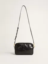 Bolso bandolera negro de cuero con efecto desgastado y estrella en relieve. Tiene correa de cuero ajustable y detalles metálicos dorados.