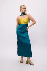 Vestido largo de satén negro con corpiño marrón con tablas y bufandín al cuello.