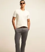 Pantalón de vestir color marrón, de corte recto, con bolsillos laterales y traseros. Se ajusta a la cintura con cinturón de cuero marrón.