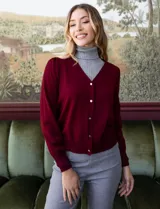 Cardigan de hilado fino color azul, con escote en V y apertura central con botones metálicos.