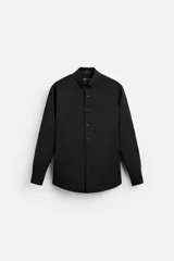 Camisa negra de corte slim fit, confeccionada en tejido que minimiza las arrugas. Tiene cuello italiano, mangas largas con puños abotonados y cierre frontal con botones.