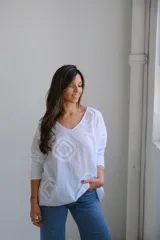 Remera blanca de algodón con cuello en V y mangas 3/4. Presenta apliques de rombos blancos en relieve.