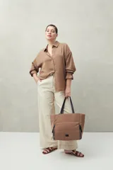 Camisa negra de manga larga con cuello clásico y botones frontales. El tejido presenta una textura arrugada o plisada, y los puños tienen un detalle fruncido o elástico.