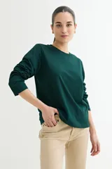 Remera verde oscuro de algodón, de manga larga y corte recto.