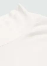 Camiseta blanca de cuello alto y manga larga, corte ajustado.