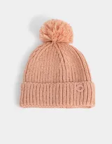 Gorro de lana tejido color rosa viejo, con pompón en la parte superior y etiqueta metálica con logo en el borde.